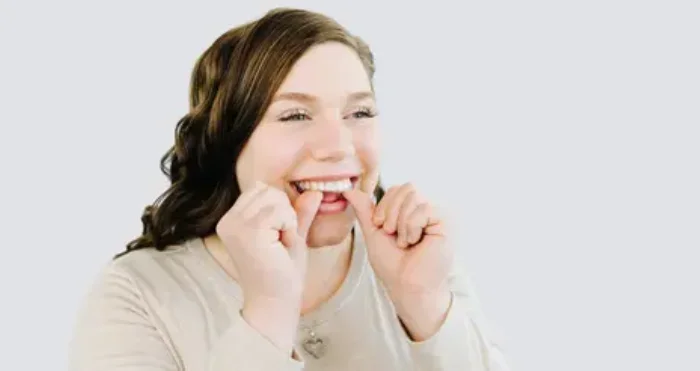 woman putting in retainers smiling